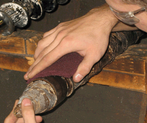 Using a Poly-Brite Abrasive Pad to remove residue from a screw